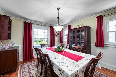 Dining room featuring dark hardwood / wood-style floors, ornamental molding, and a healthy amount of sunlight