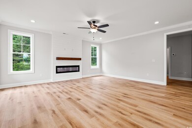 Unfurnished living room with ornamental molding, ceiling fan, baseboards, light wood-style flooring, and recessed lighting