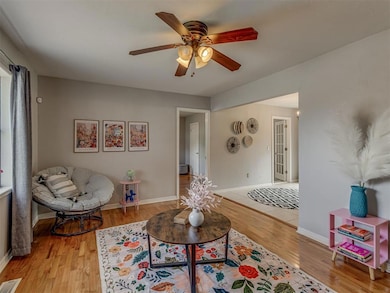 Living room featuring original wood floors  ceiling fan