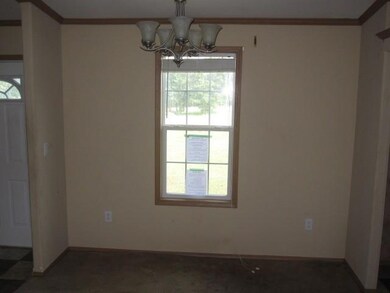 Carpeted spare room with a chandelier and crown mo