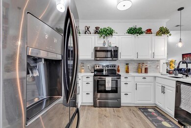 Kitchen with sink, white cabinetry, stainless stee