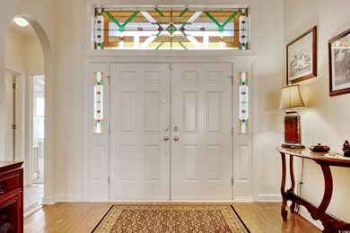 Entryway with arched walkways, baseboards, and lig