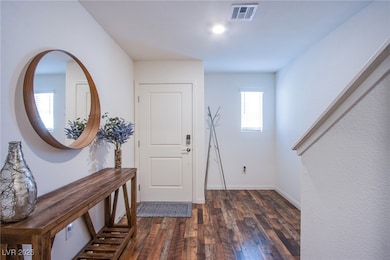 Foyer with dark wood-type flooring and baseboards
