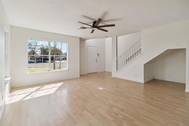 Unfurnished living room with stairway, light wood