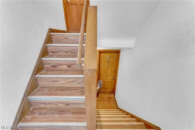 Stairway with light hardwood / wood-style floors