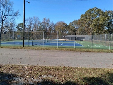 View of tennis court featuring fence
