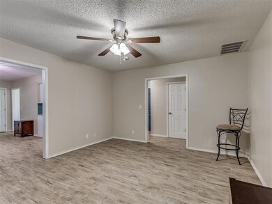 Unfurnished room with a textured ceiling, light ha