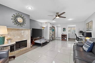 Tiled living room featuring an office area, recessed lighting, a high end fireplace, and a ceiling fan