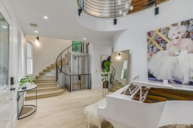 Foyer with wood finished floors, stairway, and re
