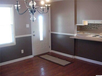 Foyer, dinning and snack bar area with wood floors, crown molding and chair rail. (New paint, light fixtures and back splash)
