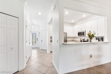 Kitchen featuring ornamental molding, light tile p