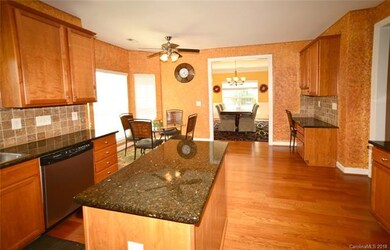 Kitchen features island, granite countertops, tile