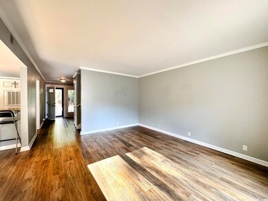 Unfurnished living room featuring crown molding an