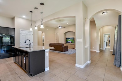 Kitchen with a ceiling fan, light tile patterned 