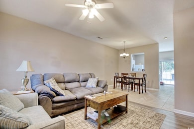 Living room with a chandelier, a ceiling fan, and light wood-type flooring