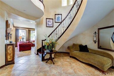 Formal entry with sweeping iron spiral staircase.