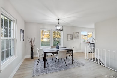 Dining room with light wood-type flooring and a chandelier