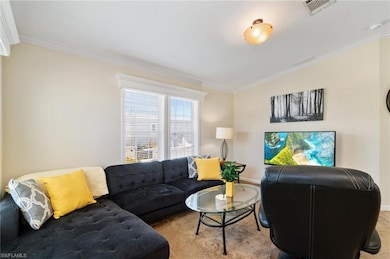 Living room featuring carpet floors, ornamental molding, and baseboards