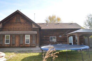 Back of house featuring a trampoline, a gazebo, a yard, and roof with shingles
