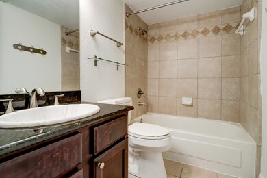 En suite bathroom with granite counter.