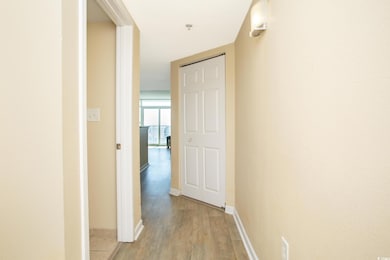 Hallway with baseboards and light wood-style floor