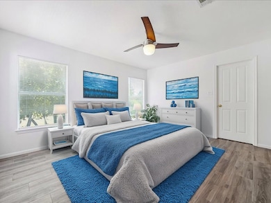Bedroom with ceiling fan and light wood-style flooring