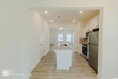 Kitchen featuring stainless steel appliances, white cabinetry, a center island with sink, recessed lighting, and a sink