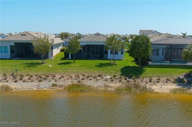 Back of house with a lake view, backyard, a tiled