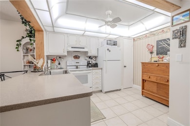 The kitchen includes a light-up tray ceiling with a fan in the middle, an extra-large sink with a garbage disposal, and a beautiful Corian countertop.