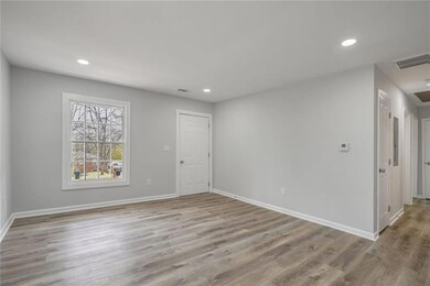 Unfurnished room featuring wood finished floors, baseboards, and recessed lighting