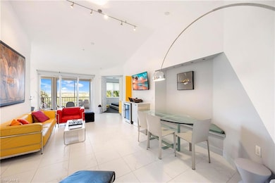 Living room featuring rail lighting and high vaulted ceiling