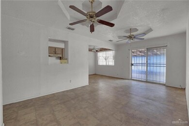 Tiled spare room with a textured ceiling and ceiling fan