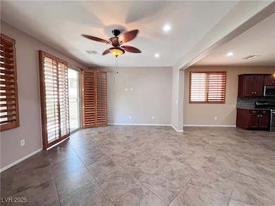 Unfurnished living room featuring ceiling fan and
