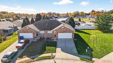 View of front of home with an attached garage, a residential view, concrete driveway, roof with shingles, and brick siding