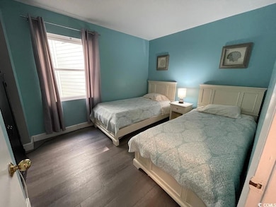 Bedroom featuring wood finished floors and baseboards