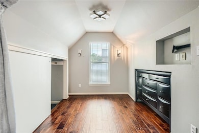 Unfurnished bedroom with dark wood-style floors, 