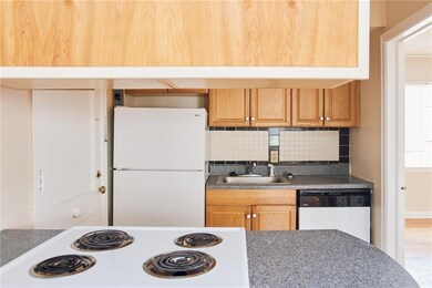 Kitchen with white appliances, a sink, and backspl