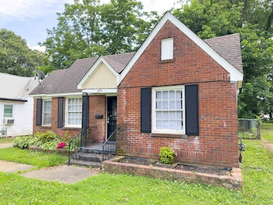 English style home with a shingled roof and brick siding