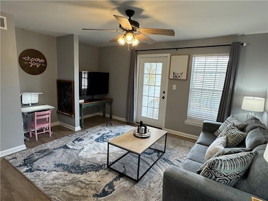 Living room featuring a ceiling fan, wood finished floors, and baseboards