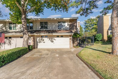 Traditional-style house with concrete driveway, an attached garage, brick siding, and a gate