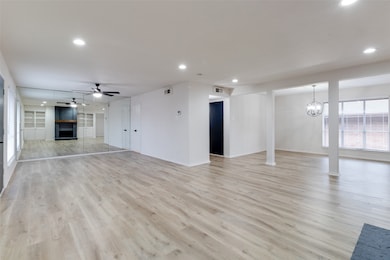 Unfurnished living room featuring a fireplace, light wood-style flooring, recessed lighting, a chandelier, and ceiling fan