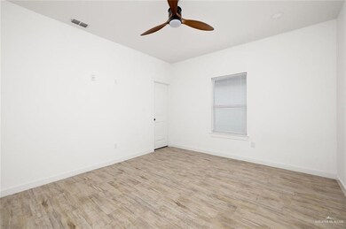 Kitchen with white cabinets, dark countertops, appliances with stainless steel finishes, and light wood-type flooring