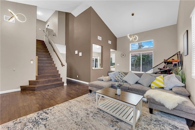 Living area featuring high vaulted ceiling, wood f