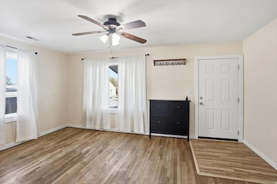 Empty room with light wood-style flooring and ceiling fan