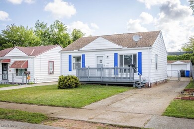 Bungalow-style home featuring a deck, a front yard, and an outbuilding