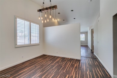 Empty room featuring dark wood-type flooring, base