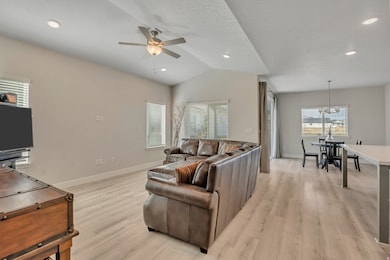 Living room featuring light wood finished floors, recessed lighting, ceiling fan, vaulted ceiling, and a textured ceiling