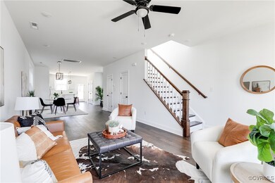 Living room featuring a ceiling fan, stairway, and