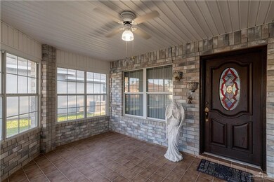 Property entrance featuring ceiling fan and a porch