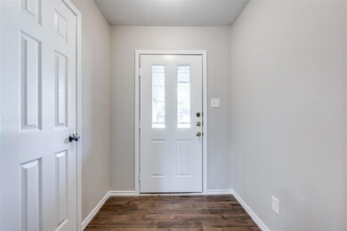 Entryway with dark wood-style floors and baseboard